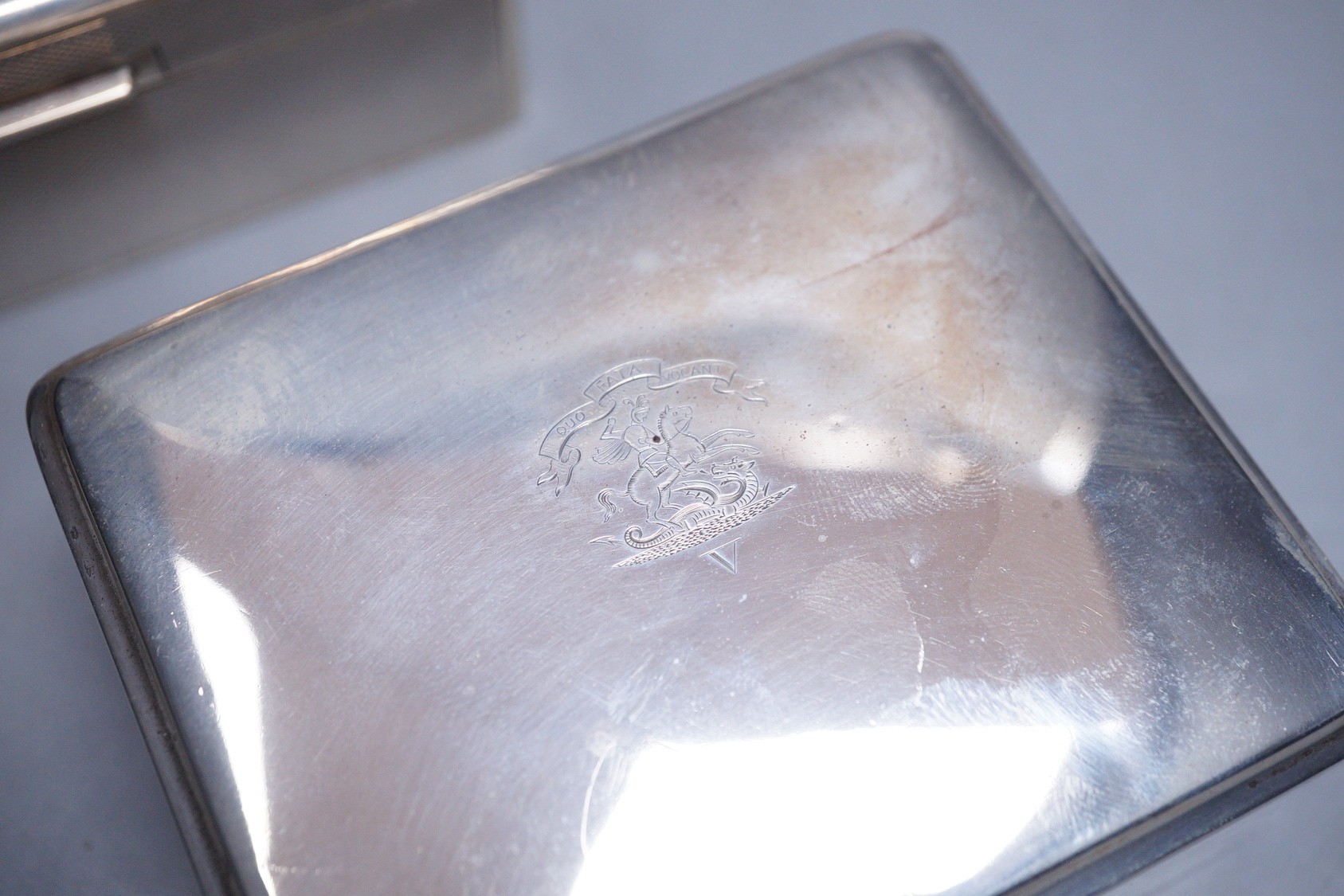 A late 1950's engine turned silver mounted rectangular cigarette box, by Mappin & Webb, 14cm and one other smaller silver mounted cigarette box.